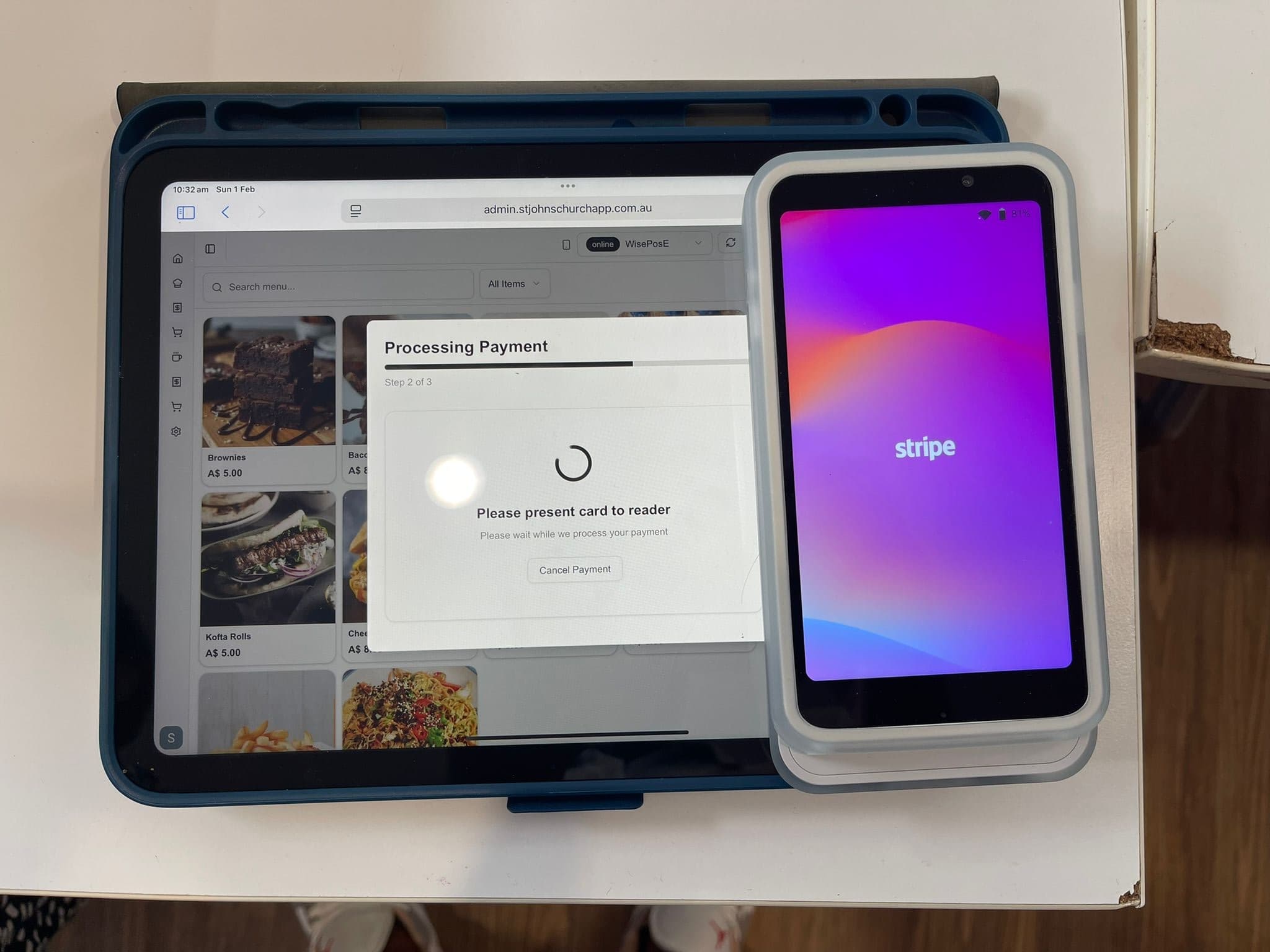 A tablet running the counter POS, asking for a card to be presented to the reader beside it