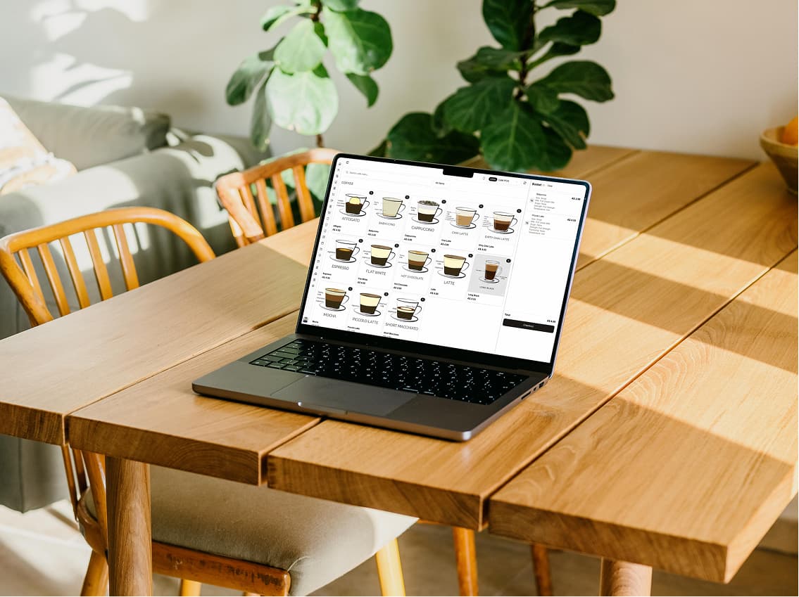 The cafe POS open on a laptop, its coffee menu laid out as a grid of tiles
